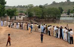 Pakistani voters queue outside a polling